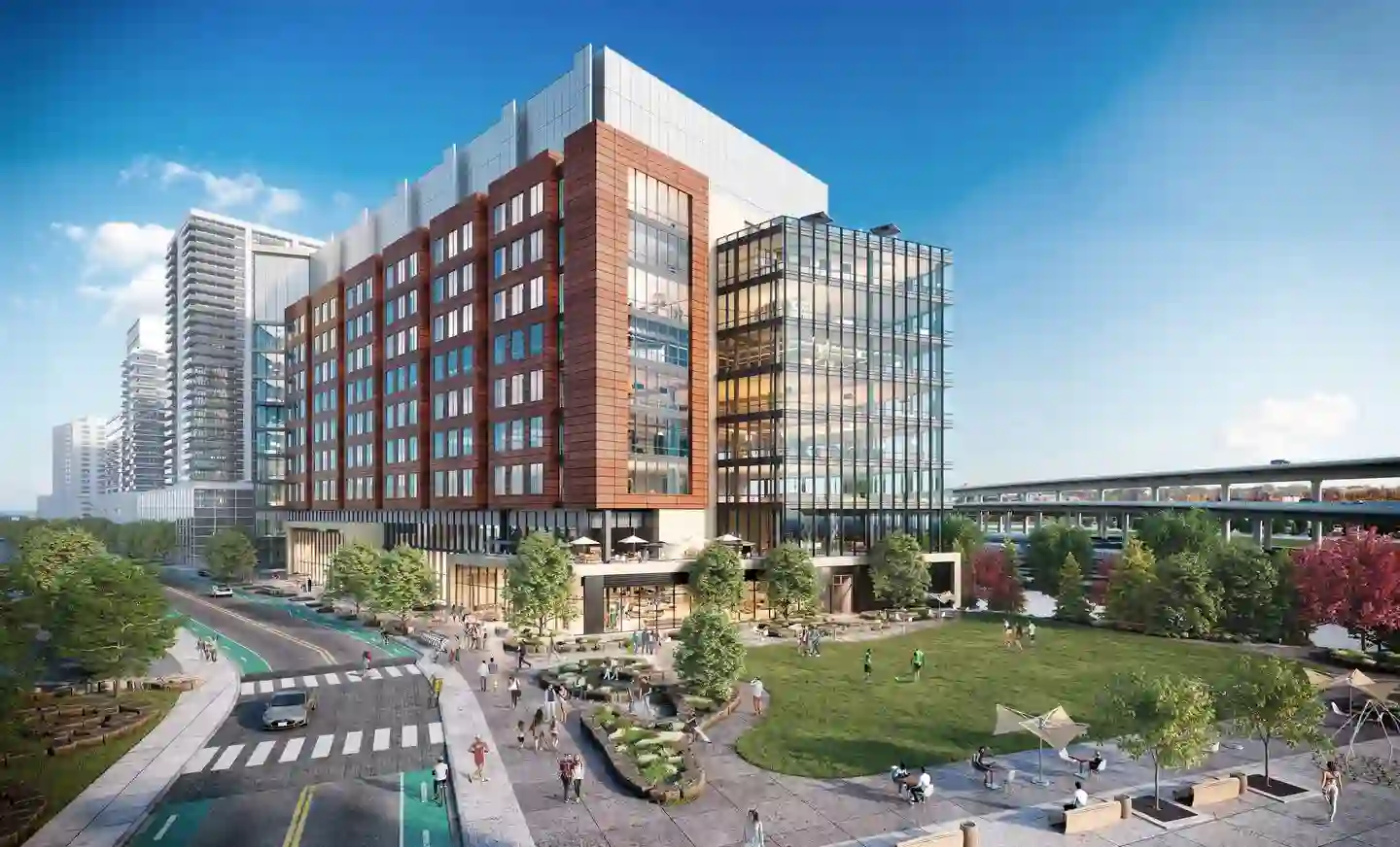 Modern red brick and glass commercial building in a Boston biotech hub with surrounding park space.