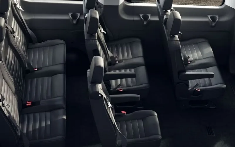 Custom Mercedes-Benz Sprinter Van interior with quilted leather seats and blue ambient LED lighting