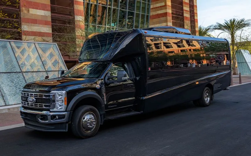 Front three-quarter view of a black 28 PAX Mini Coach for group executive transportation