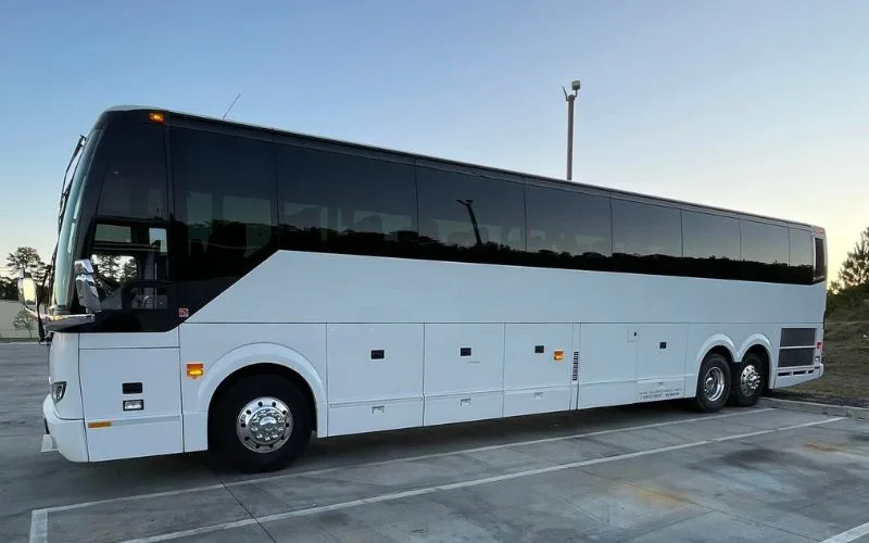 Front three-quarter view of a black 56 PAX Motor Coach designed for large-scale executive group travel