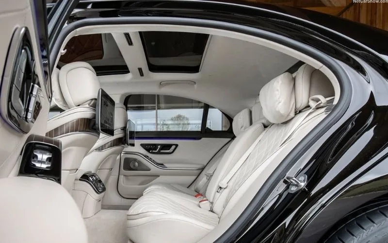 Interior view of Mercedes-Benz S-Class rear seats with a panoramic roof and ambient lighting