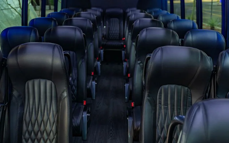 Interior view of a 28-passenger executive shuttle featuring a high-end dashboard and entertainment system