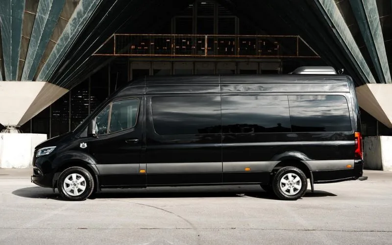 Side profile of a black Mercedes-Benz Sprinter Limo with tinted windows for executive transportation